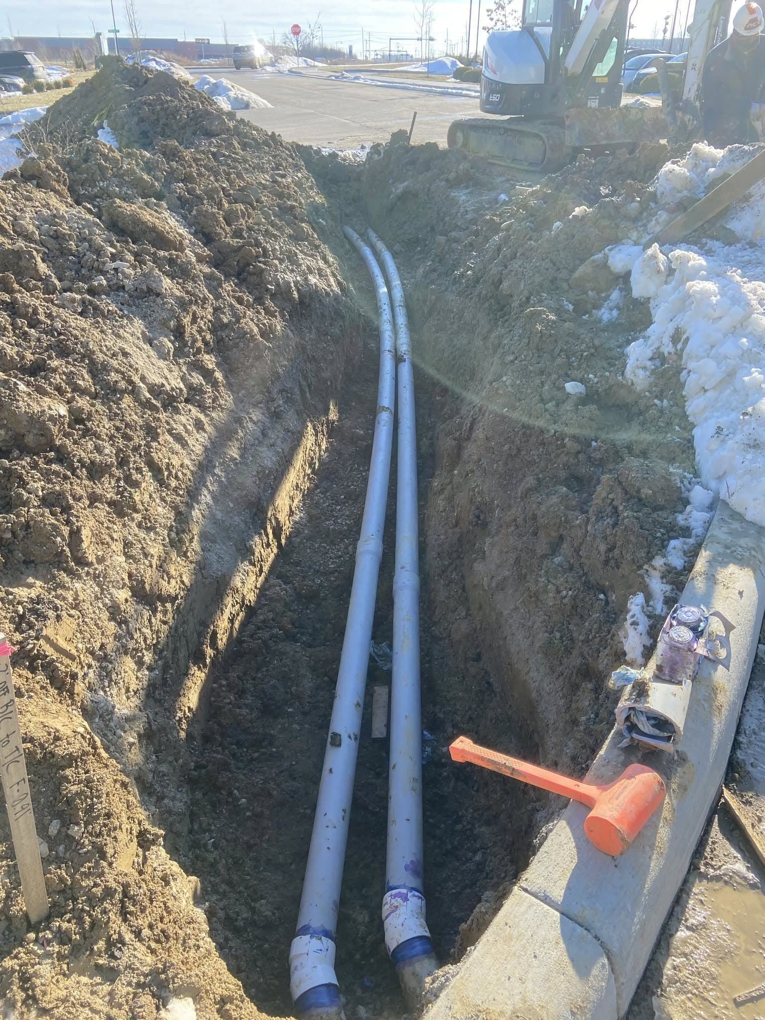 Utility trench excavation with pipe installation
